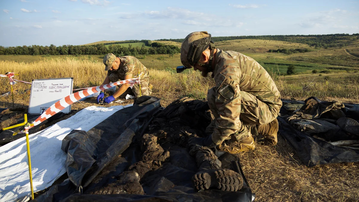 Члены украинской поисковой группы перекладывают останки российских солдат вблизи линии фронта в районе Бахмута, Донецкая область, 1 августа 2024 года. Фото: Nikoletta Stoyanova / EPA